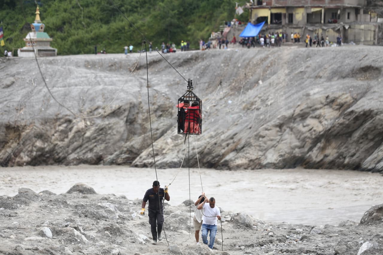 बाढीले पुल बगाएपछि तुइनबाट त्रिशूली वारपार गर्दै स्थानीय (तस्बिरहरू)